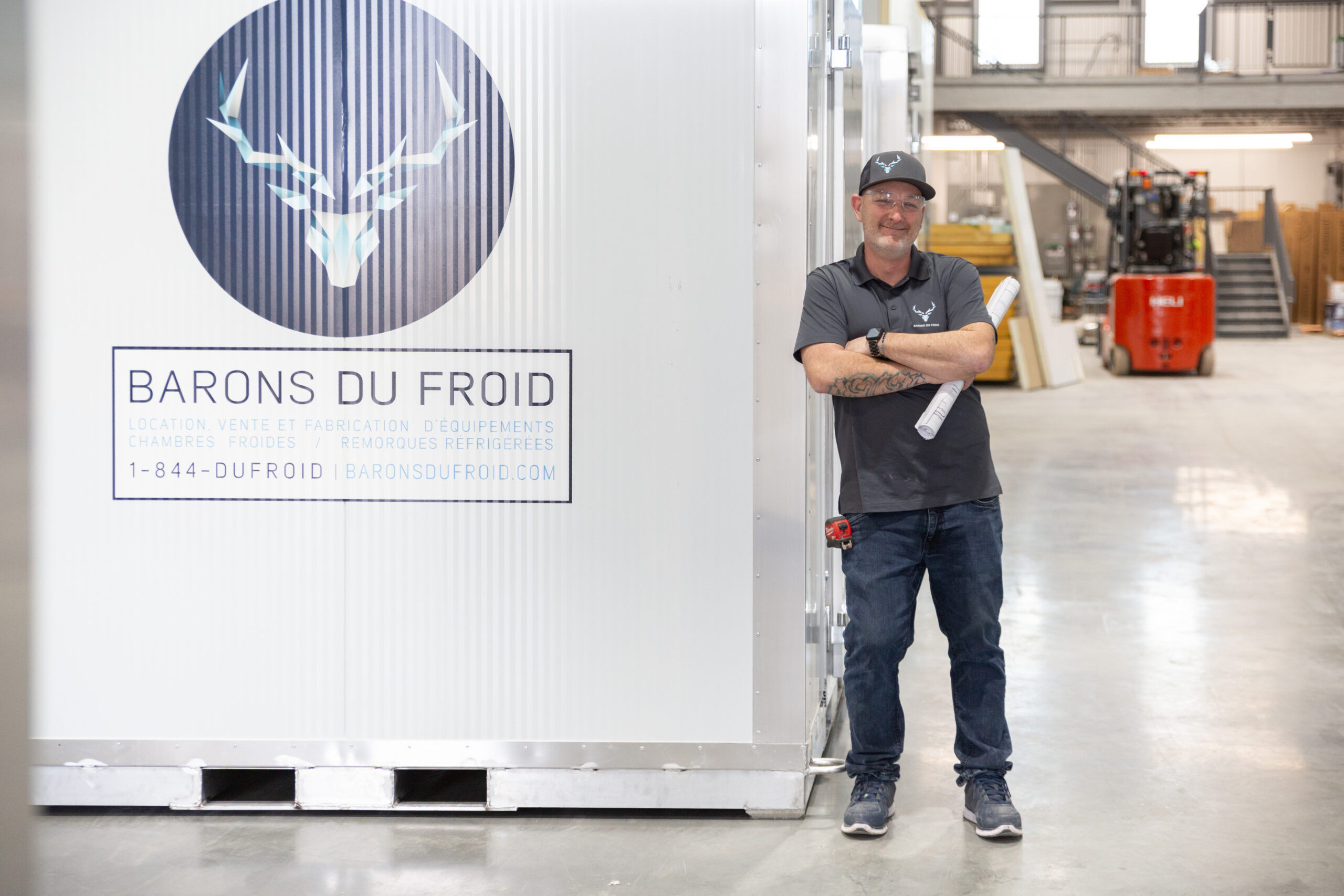 Collègue souriant en uniforme Barons du Froid, avec un plan dans les mains